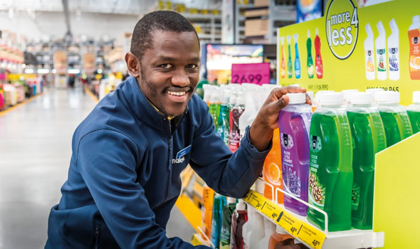 A smiling associate stocks shelves.