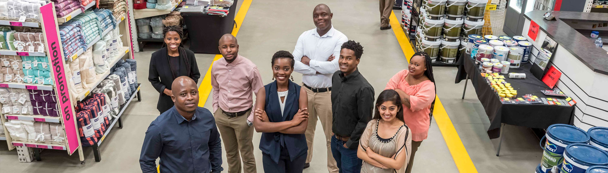 Massmart associates stand in an aisle in a store, looking up at the camera confidently.