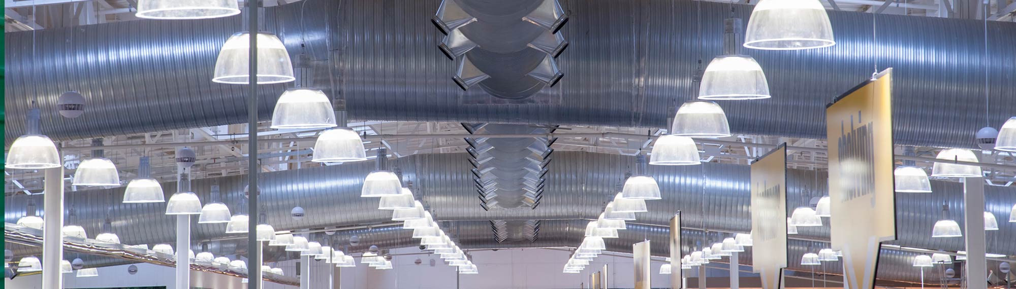 Rows of high-efficiency lighting hang from the ceiling of a large store.